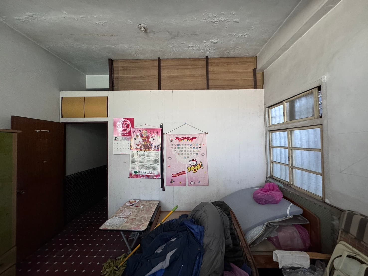 鎮中路老屋二樓臥室翻修前,堆滿雜物與老舊窗戶